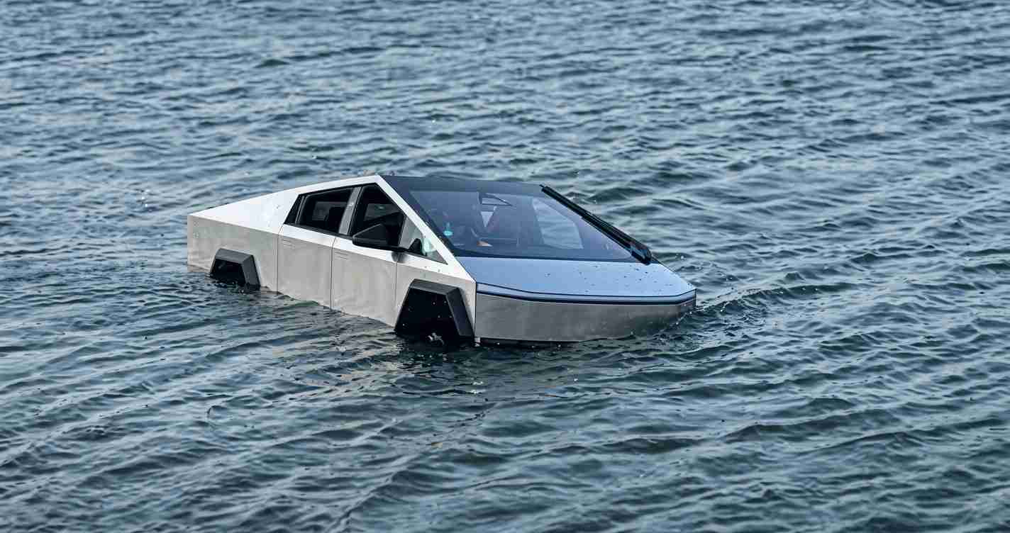 Wedge-shaped silver car partially submerged in ocean water, front end floating.