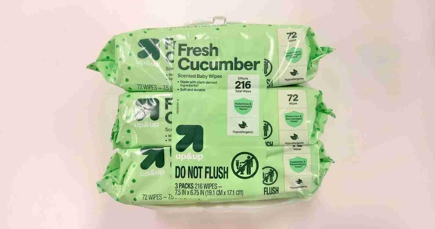 Stack of green Fresh Cucumber baby wipes packages (Up & Up) labeled 72 wipes with 'DO NOT FLUSH' visible.