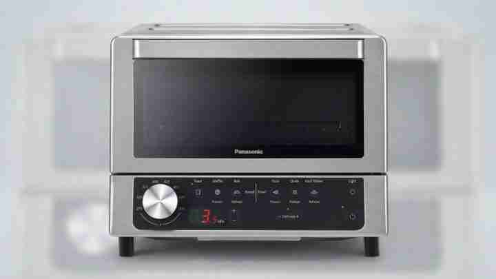 Stainless steel countertop oven/microwave with a large circular control knob and digital timer display on the front panel.