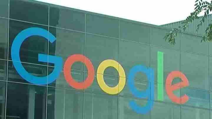 Google logo in blue, red, yellow, and green on a glass office building facade
