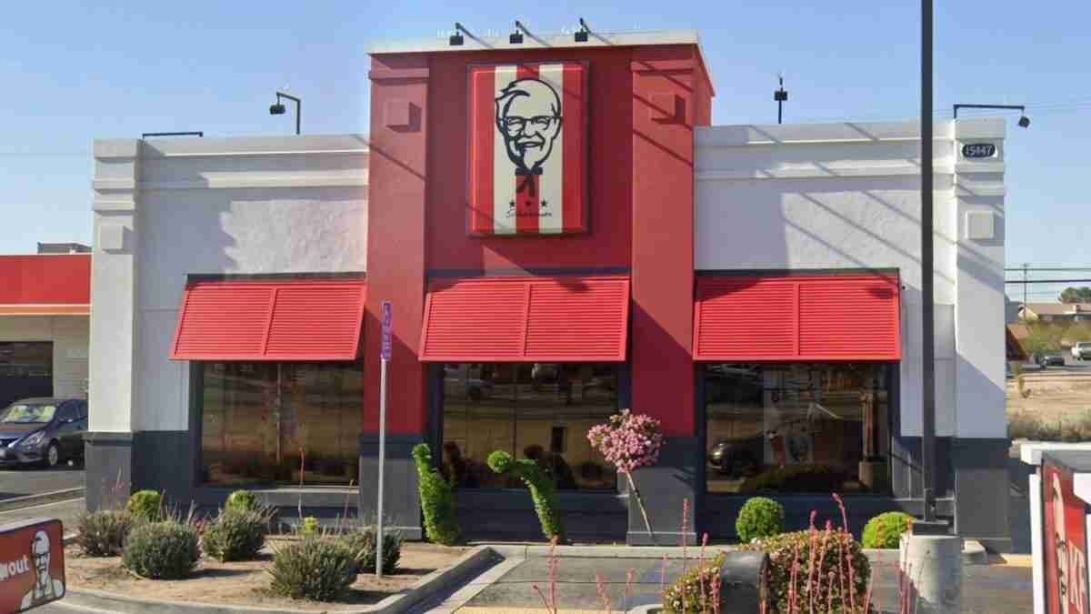 KFC restaurant with red exterior, large Colonel Sanders sign above the entrance, and red awnings.